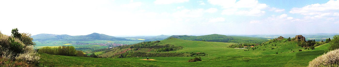 Talblick vom Nordhang des Hohen Dörnberg Richtung Nordwesten. Der Berg ganz links, der schon leicht im Gegenlicht liegt, ist der Große Bärenberg (601 m). Mittig links liegt oberhalb der Wacholderheide Zierenberg. In der Bildmitte sieht man den unbewaldeten kleinen Dörnberg (481 m) mit Segelflugplatz. Ganz rechts erheben sich die Helfensteine (510 m)