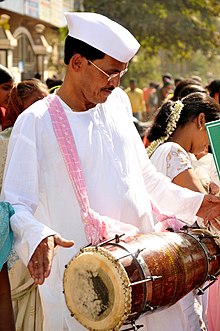 A man playing dholki in a procession.jpg