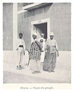Photo of four people and a baby in front of a building, looking at the camera