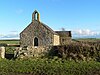 A plain block stone church with an arched doorway