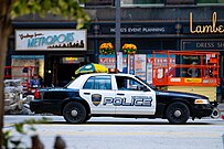 A Metropolis Police car on a Cleveland street in the foreground with a "Greetings from Metropolis" sign in the background