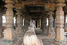 An old hall with stone pillars and a statue of a bull