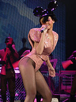 Rihanna wearing a pale orange, sequinned dress and Mickey Mouse ears