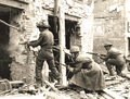 A Canadian soldier fires on the enemy in a house in Caen, July 10, 1944.