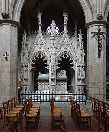 Photo représentant un tombeau monumental néogothique en pierre blanche, dans un bas-côté d'église