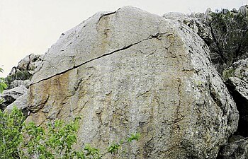 Resimli sembollerle yazılmış turuncu bir kayanın fotoğrafı