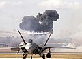 The Pearl Harbor reenactment of "Tora! Tora! Tora!" fills the sky with smoke as a Japanese Zero streaks by behind an F-22 Raptor during AirFest 2008 at Lackland Air Force Base, Texas.