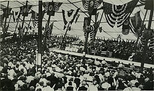 A large crowd in a tent with many flags