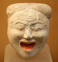 A Han pottery face of a laughing woman