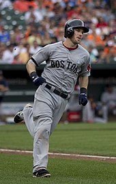 A baseball player wearing a gray uniform and black helmet runs the bases.