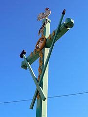 Croix en bois ornée de treize cœurs