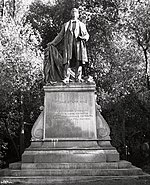 Stone statue of a standing man on a stone pedestal