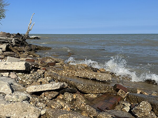 Lake Michigan waves crash onto concrete, brick, and rebar refuse along the shore of North Point, Milwaukee, WI