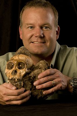 Lee Rogers Berger laat de schedel van een Australopithecus sediba ter vergelijking zien.