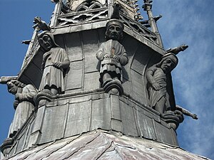 Cariatiden aan de voet van de torenspits boven het koor