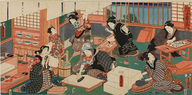 Barevný tisk skupiny elegantně oblečených japonských žen, které tisknou. Autor Kunisada, 1857. Skutečná tiskárna by nebyla osazená takovými kráskami.