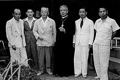 Photographie de Ngo Dinh Thuc et son frère Ngô Đình Diệm à sa droite avec d'autres hommes au Japon en 1950