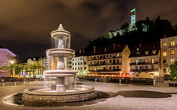 Vista noturna da fonte barroca Turjak na Praça Nova, com o Castelo de Liubliana ao fundo, Liubliana, Eslovênia. A praça, de forma retangular, é delimitada a leste pelo rio Ljubljanica, a oeste a praça faz fronteira com a rua dos Nobres e aqui se origina a rua Turjak. Vários edifícios de estilo barroco dominam a praça: no extremo oeste, no número 3, fica o Palácio Lontovž, sede da Academia Eslovena de Ciências e Artes; nos números 2 e 4 dois edifícios quinhentistas reformados no século XVIII, com interiores valiosos. Na parte baixa da praça, em direção ao rio, existe uma fonte composta por quatro tanques. (definição 7 861 × 4 876)