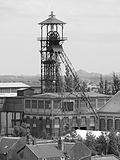 Photographie du chevalement du puits n° 11 de la fosse n° 11 - 19 des mines de Lens à Loos-en-Gohelle prise depuis le terril conique n° 74, 11 - 19 de Lens Est. Ce chevalement est classé aux monuments historiques et inscrit sur la liste du patrimoine mondial de l'Unesco.