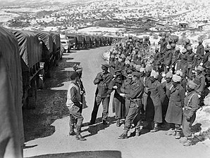 Indian soldiers stand next to supply convoy en route to Soviet Union