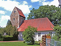 Naturdenkmal Eiche halb verdeckt vom Kirchenschiff in Neindorf