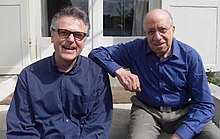 Martial Solal et le saxophoniste Wolfgang Bleibel, tous les deux souriants, assis côte à côte sur des marches d'escalier en 2013. Solal est à droite sur l'image, en chemise bleue, le bras droit sur l'épaule de Bleibel, en chemise bleue également.