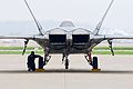 A crew chief for the U.S. Air Force F-22 Raptor aerial demonstration team chocks a Raptor's wheel April 16 on the flightline of the Kentucky Air National Guard base in Louisville, Ky. The team will be participating in the Thunder Over Louisville air show April 18.