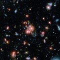 Imagen del cúmulo de galaxias SpARCS1049 que capturó el Spiter y el telescopio espacial Hubble.[17]​