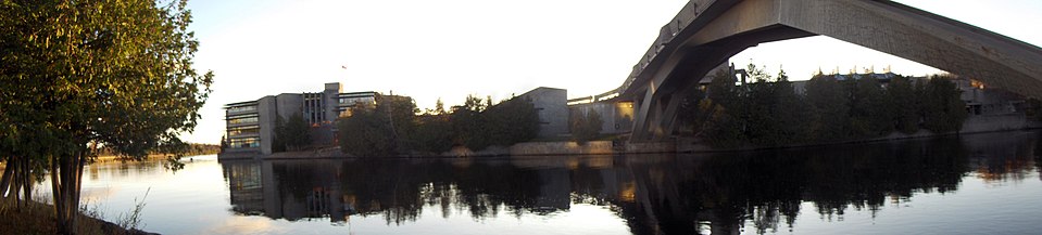 A view across the Otonabee river in Peterborough, Ontario, showing a part of the campus of Trent University. The Faryon bridge is to the right.