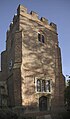 St Mary's brick-built, early 16th-century tower (with later crenellation), diagonal buttresses and square-headed three pane window above wooden door