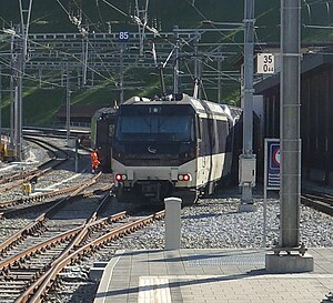 Der umgespurte GPX-Zug wird weiter nach Montreux geschoben. Links dahinter: Interfacewagen und BLS-Lok, die den Zug von Interlaken nach Zweisimmen gezogen hat, auf normalspurigem Stumpfgleis am Südkopf des Bahnhofs (von links nimmt dieses das zweite Normalspurgleis auf).