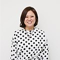 Smiling woman wearing white dress with black polka dots