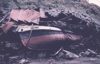 En båd kastet op på et hus af tsunamibølgen