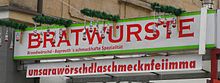 Unsere Würstchen schmecken für wahr immer - Werbeschrift bei einem Bratwurststand in der Fußgängerzone