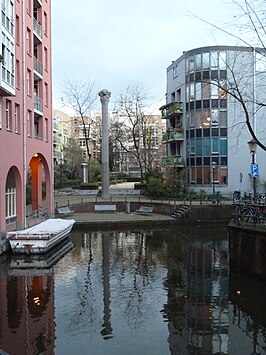 Snoekjesgracht gezien naar het noorden, met bebouwing uit de jaren tachtig en het pilaarvormig kunstwerk van Wim Tap