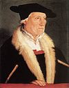 Den tyske geografen Sebastian Münster portrettert av Christoph Amberger ca. 1550. Baretter med egne nedbretter over ørene utviklet seg til dommer- og advokatluer og seinere den firkantede studenterlua Oxford cap.