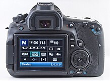 Agteraansig van 'n Canon 60D met 'n snelbeheerknop net regs van die LCD-skerm.