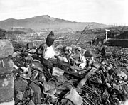 Battered religious figures stand watch on a hill above a tattered valley. Nagasaki, Japan. September 24, 1945