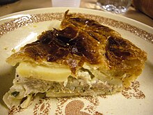 Quartier de tourte qui montre clairement les couches de pâte et les morceaux de pomme de terre.