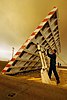 An airman aboard an aircraft carrier greases a part of a jet blast deflector.