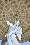 Photographie en contre-champs de la statue laissant apparaître la voûte à caissons en fond