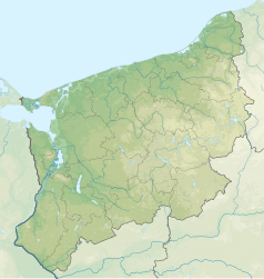 Mapa konturowa województwa zachodniopomorskiego, po lewej nieco na dole znajduje się owalna plamka nieco zaostrzona i wystająca na lewo w swoim dolnym rogu z opisem „Grzybno”