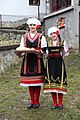 Two girls dressed in traditional costume wish a traditional welcome with bread and salt to the guests in the village of Konopnica, North Macedonia