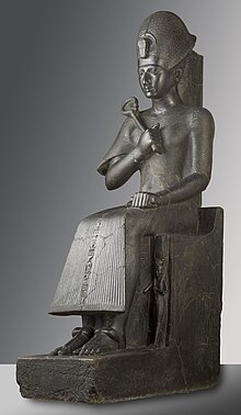 Statue grise montrant un homme assis
