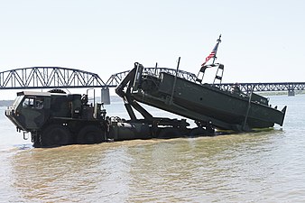 Soldados del Ejército de EE.UU. descargan un barco de construcción de puentes Mk2 de un M1977A2 CBT HEMTT en el río Misuri.