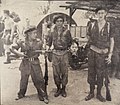 Commonwealth soldiers in a British military base pose with a severed head