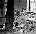 Typical street scene: garbage, shot-up cars, buildings pockmarked by bullets.