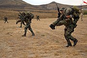 Students simulating moving comrades during a live fire exercise on Camp Pendleton.