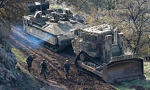 Un Namer CEV d'un bataillon du génie de combat suivant un bulldozer Caterpillar D9 lors d'un exercise en janvier 2023.