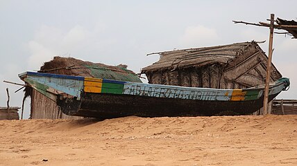 Sea fishing boat and fishermen's huts on Grand-Popo beach. Sea boats and sea fishing came to the area in the 19th century.